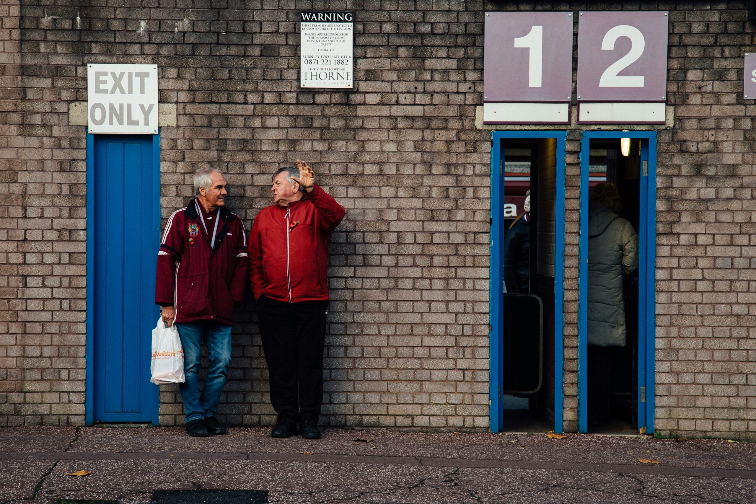 Two men outside a Football Stadium