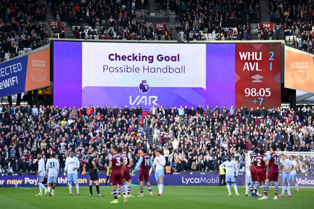 Picture of the screen in the London Stadium with many anxious fans waiting on the decision.